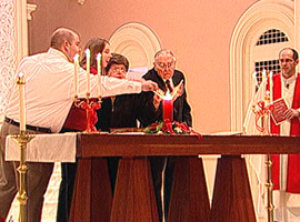 The longest-married couple and newest married couple light the unity candle together at the Mass for Lovers