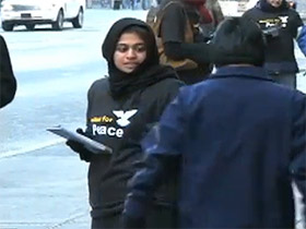 An Ahmadiyya Muslim volunteer hands out flyers in Times Square