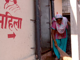 Mamta Bidlan cleaning around a public toilet facility for women