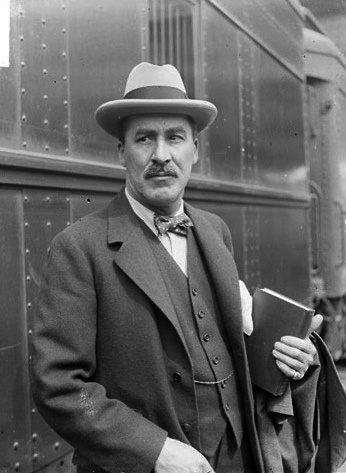 Informal portrait of Howard Carter (the archaeologist) standing with a book in his hand next to a train at a station in Chicago, Illinois. 1924, The Library of Congress (USA), Chicago Daily News, Inc., photographer