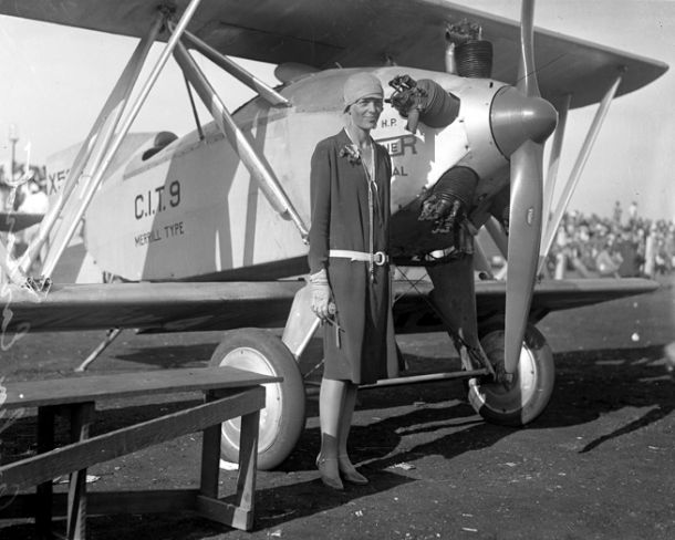 Amelia Earhart — wearing a dress, standing beside a plane, circa 1928. Publication:Los Angeles Daily News Publication date:1928 Source:Los Angeles Times photographic archive, UCLA Library 