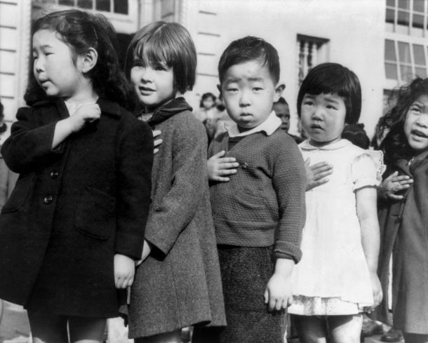 First-graders, some of Japanese ancestry, at the Weill public school, San Francisco, Calif., pledging allegiance to the United States flag. April 1942. Photo attributed to Dorothea Lange